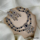 Ornate necklace with blue stones on a white fabric background