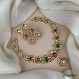 Gold necklace with gemstones on a white fabric background