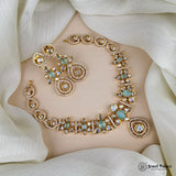 Ornate gold and gemstone necklace on a white fabric background