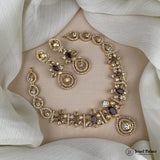 Gold necklace with purple stones on a mannequin bust against a white fabric background