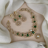 Ornate gold and green gemstone jewelry set on a neutral background