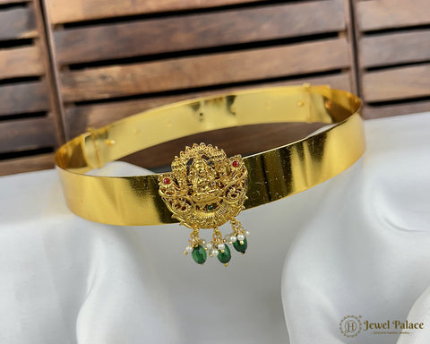 Gold bracelet with decorative elements on a white surface