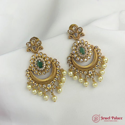 Gold earrings with green stones and pearl drops on a white surface, branded 'Jewel Palace'.