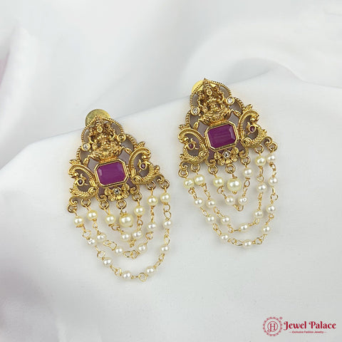 Gold and purple earrings with pearl chains on a white mannequin.