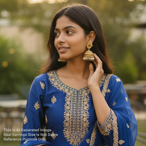 Woman wearing a blue embroidered outfit with gold jewelry outdoors
