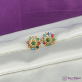 Colorful gemstone earrings on a white fabric with a purple background