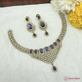 Necklace and earrings set with blue stones on a white fabric background, brand 'Jewel Palace' visible.