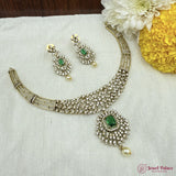 Jewelry set with necklace and earrings on a white fabric background with flowers.