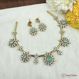 Jewelry set with necklace and earrings on a textured surface with flowers.