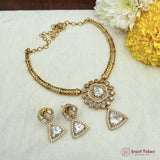 Gold necklace and earrings set with 'Jewel Palace' branding on a light fabric background.