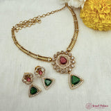 Jewelry set with necklace and earrings on a textured surface with flowers.