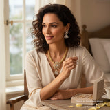 Woman wearing gold jewelry in a cozy indoor setting