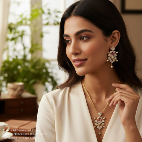 Woman wearing a gold necklace and earrings in a blurred indoor setting