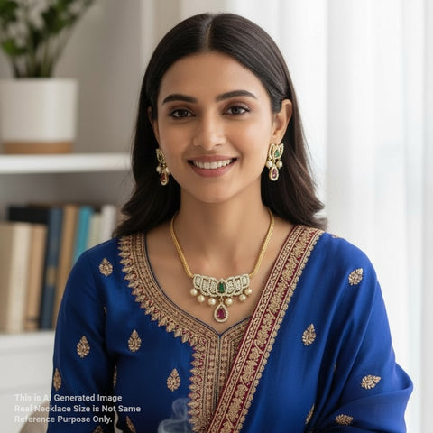 Woman wearing traditional jewelry and a blue embroidered outfit indoors.