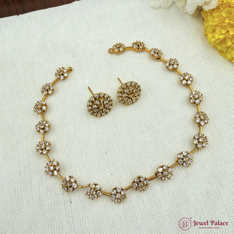 Gold necklace and earrings set on a textured white surface with 'Jewel Palace' branding.