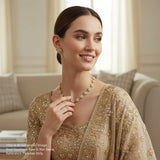 Woman wearing a gold necklace and earrings in a living room setting