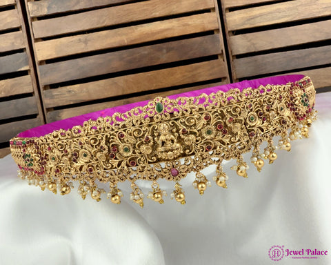 Gold jewelry with purple cushion on a wooden background