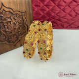 Gold bangles with gemstones on a white surface, with 'Jewel Palace' branding.