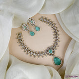 Jewelry set with necklace and earrings on a white fabric background