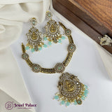 Ornate gold and green necklace set on a white fabric background with 'Jewel Palace' branding.