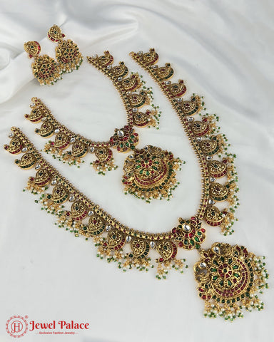 Ornate gold necklace with green and red stones on a white background, branded 'Jewel Palace'.