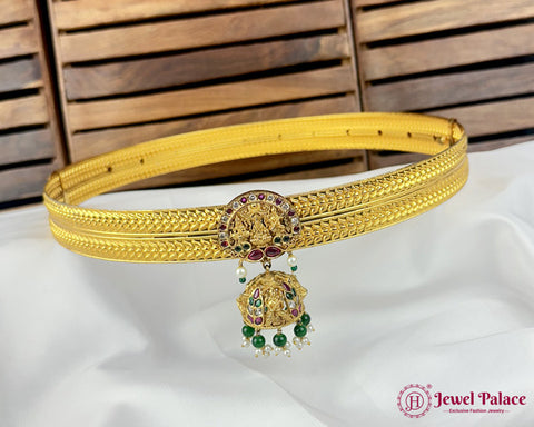 Gold belt with decorative elements on a white fabric background