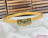 Gold belt with decorative clasp on a white fabric background