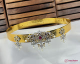 Decorative gold belt with intricate designs and pearls on a white surface.