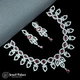 Jewelry set with necklace and earrings featuring red gemstones on a black background, branded 'Jewel Palace'.