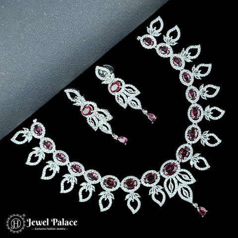 Jewelry set with necklace and earrings featuring red gemstones on a black background, branded 'Jewel Palace'.