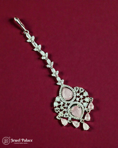 Decorative pendant with pink stones and silver detailing on a red background