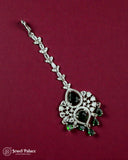 Decorative hairpin with black and green gemstones on a maroon background