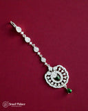 Silver jewelry with green gemstones on a red background