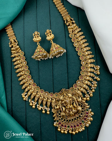 Gold necklace and earrings on a green fabric background with 'Jewel Palace' branding.