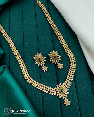 Gold necklace and earrings set on a green fabric background with 'Jewel Palace' branding.