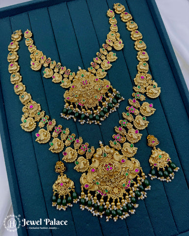 Ornate gold necklace with green and red stones on a teal background, brand 'Jewel Palace' visible.