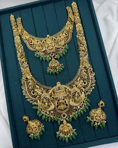Ornate gold necklace with green and red stones on a teal background, brand 'Jewel Palace' visible.