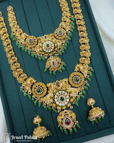Ornate gold necklace with green and red stones on a teal background, brand 'Jewel Palace' visible.