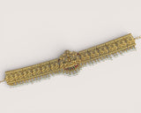 Decorative gold bracelet with intricate designs on a light gray background