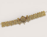 Decorative gold bracelet on a light gray background