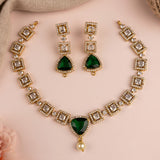 Gold-plated jewelry set featuring a necklace, matching earrings, and a bracelet, decorated with clear rhinestones and a large green teardrop gemstone at the center of the necklace, with a small pearl pendant hanging below.