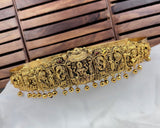 Decorative gold headband with intricate designs on a white surface with wooden background