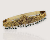 Gold belt with green gemstones on a white background