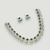 Jewelry set with necklace and earrings featuring black stones on a light gray background