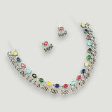 Necklace and earrings set with multicolored stones on a light gray background
