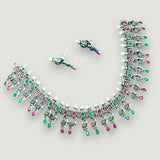 Silver necklace with green and pink stones on a light gray background