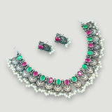 Necklace and earrings set with gemstones on a light gray background