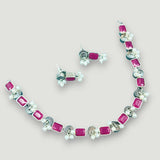 Necklace and earrings set with pink gemstones on a light gray background