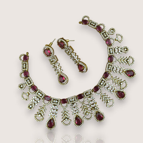 Necklace and earrings set with red gemstones on a light background