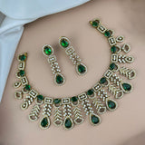 Ornate necklace and earrings with green gemstones on a person's shoulder.